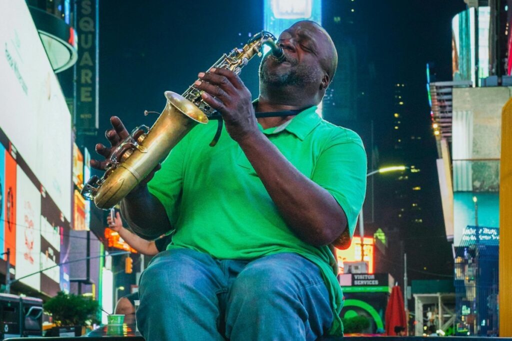 Un músico tocando el saxo en un lugar concurrido. La escena está llena de luces y energía. #BaoLiba México Conectando Marcas e Influencers Globalmente