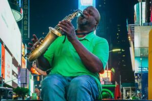 Un músico tocando el saxo en un lugar concurrido. La escena está llena de luces y energía. #BaoLiba México Conectando Marcas e Influencers Globalmente